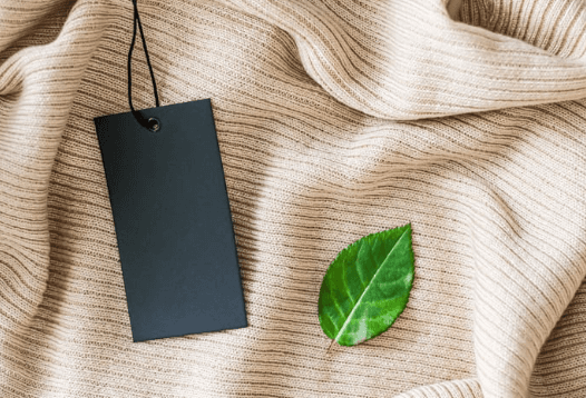 A tag and a leaf on a sweater.