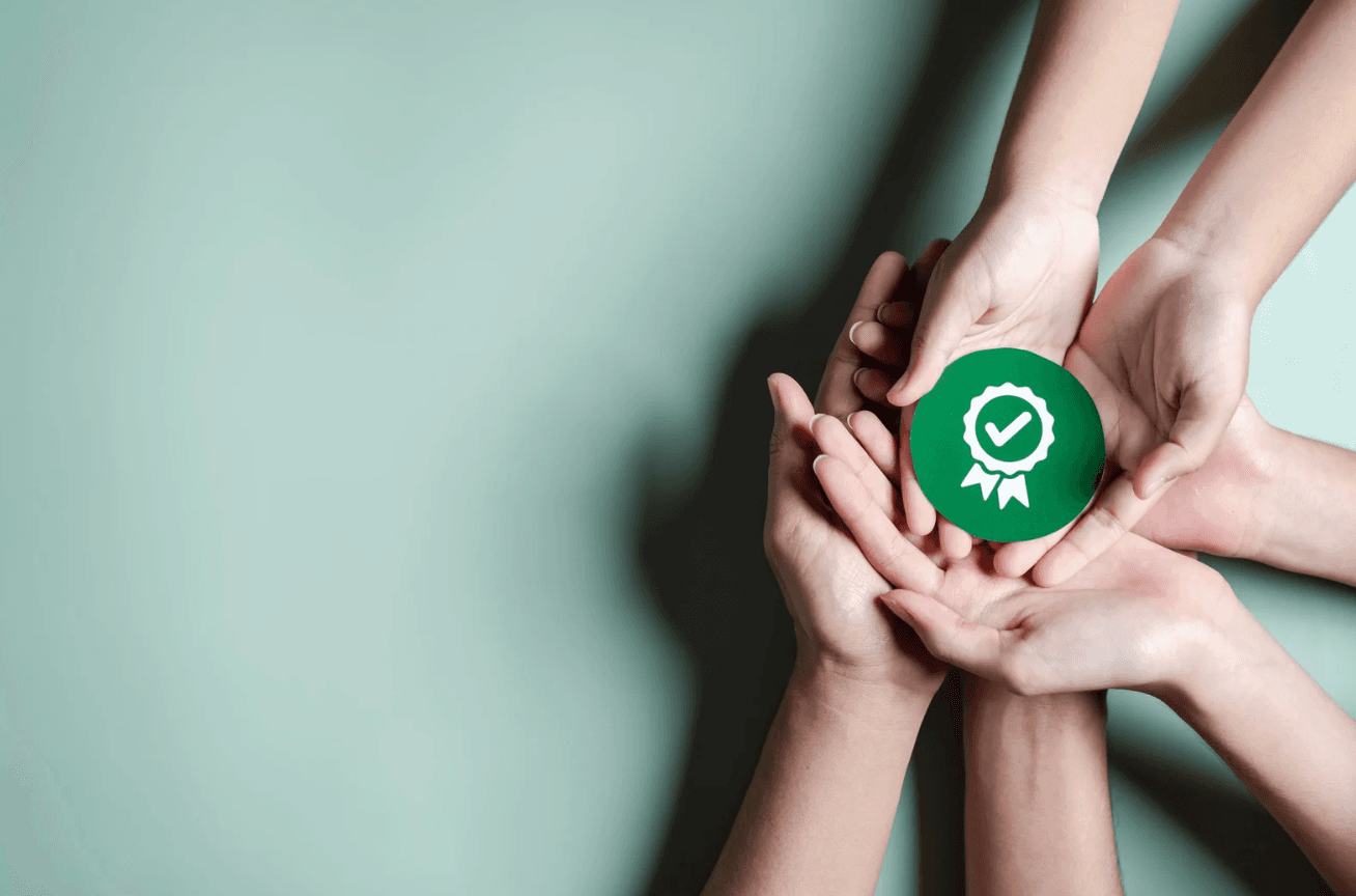 Three pair of hands holding a green circle with a symbol of a diploma.