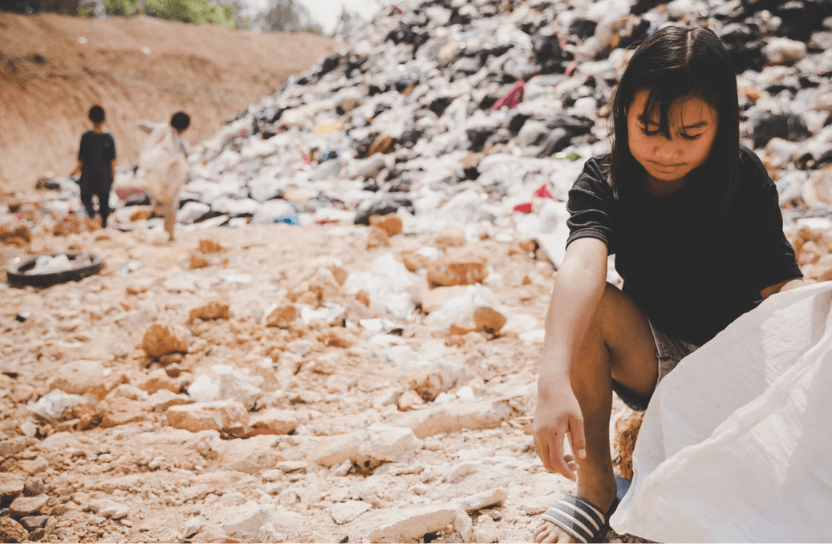 Girl in front of a pile of garbage.