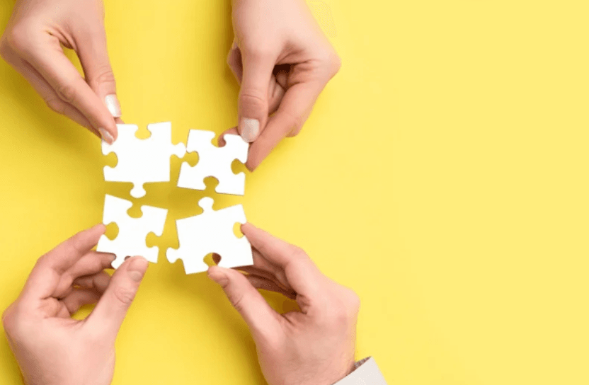 Hands holding puzzle pieces.
