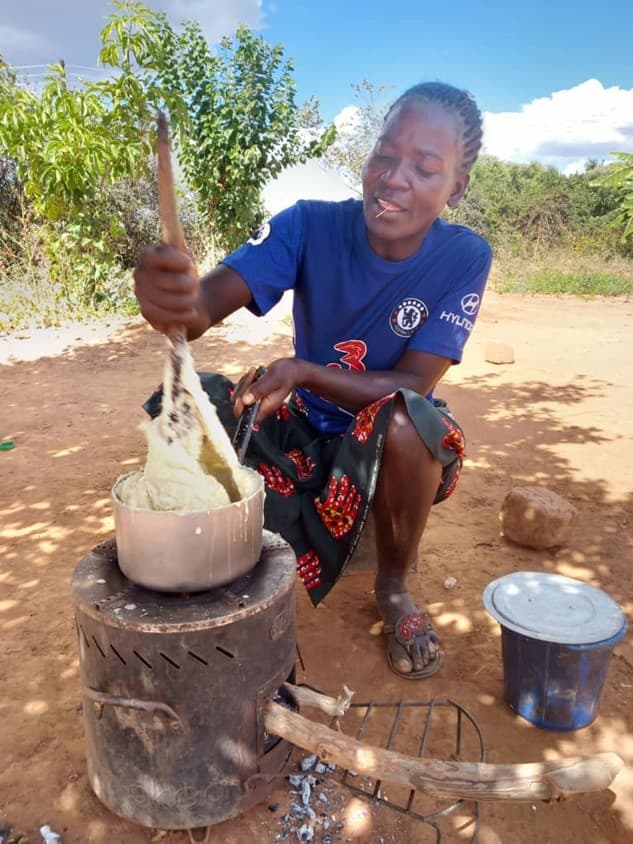 Maureen Mweleka, project participants, using a cookstove.