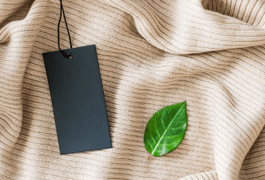 A tag and a leaf on a sweater.